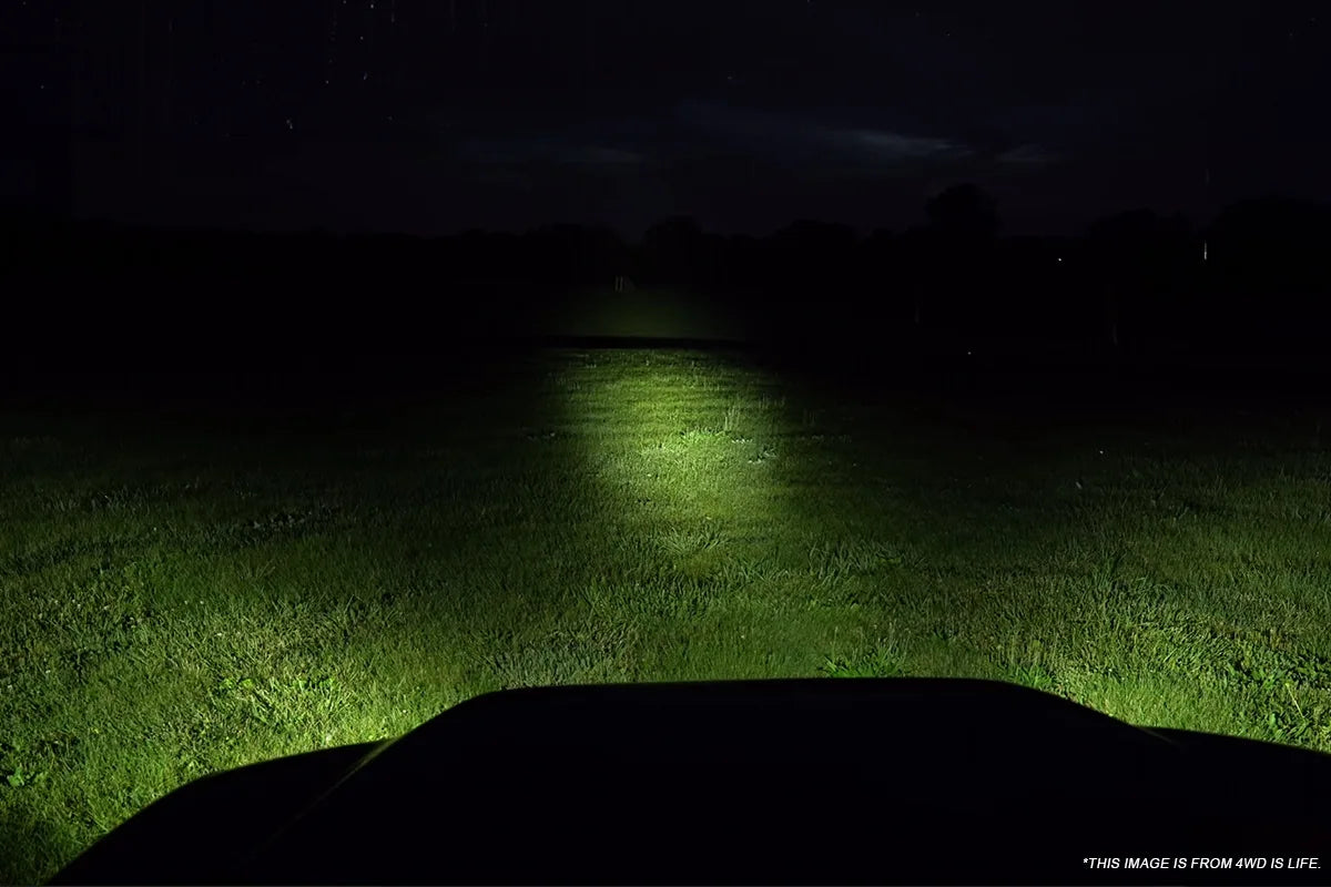 Driver view over the hood with white auxiliary lighting directed onto the route ahead