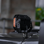 Side view of SUPAREE HYPER 5in IP68 LED off-road pod light mounted on hood bracket, showing heat sink and amber side marker