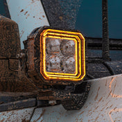 SUPAREE HYPER Series 5-inch LED Pod Lights with Stepped Halo, DRL, IP69K Waterproof installed on Jeep Wrangler JL – Close-up of muddy LED pod with amber halo DRL.
